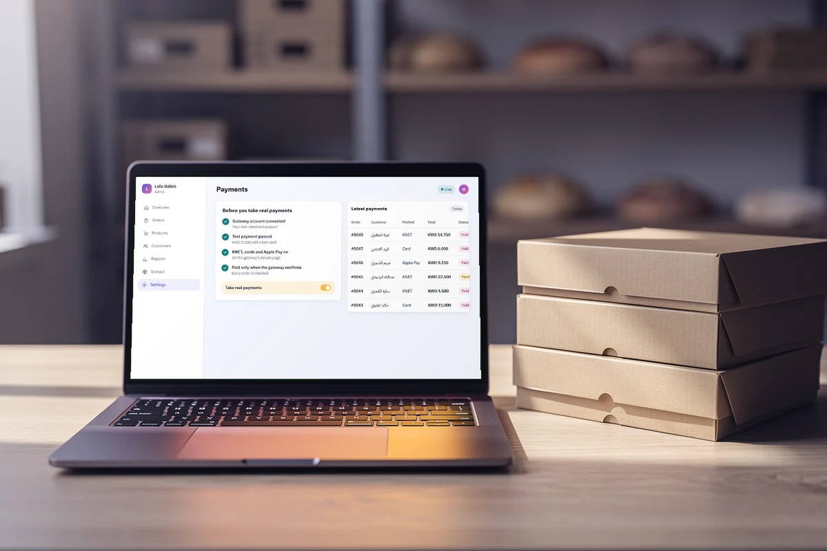 A laptop in a bakery office showing the payments page: gateway connected, test payment passed, live.